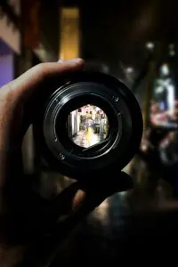 Person Holding Black Camera Lens
